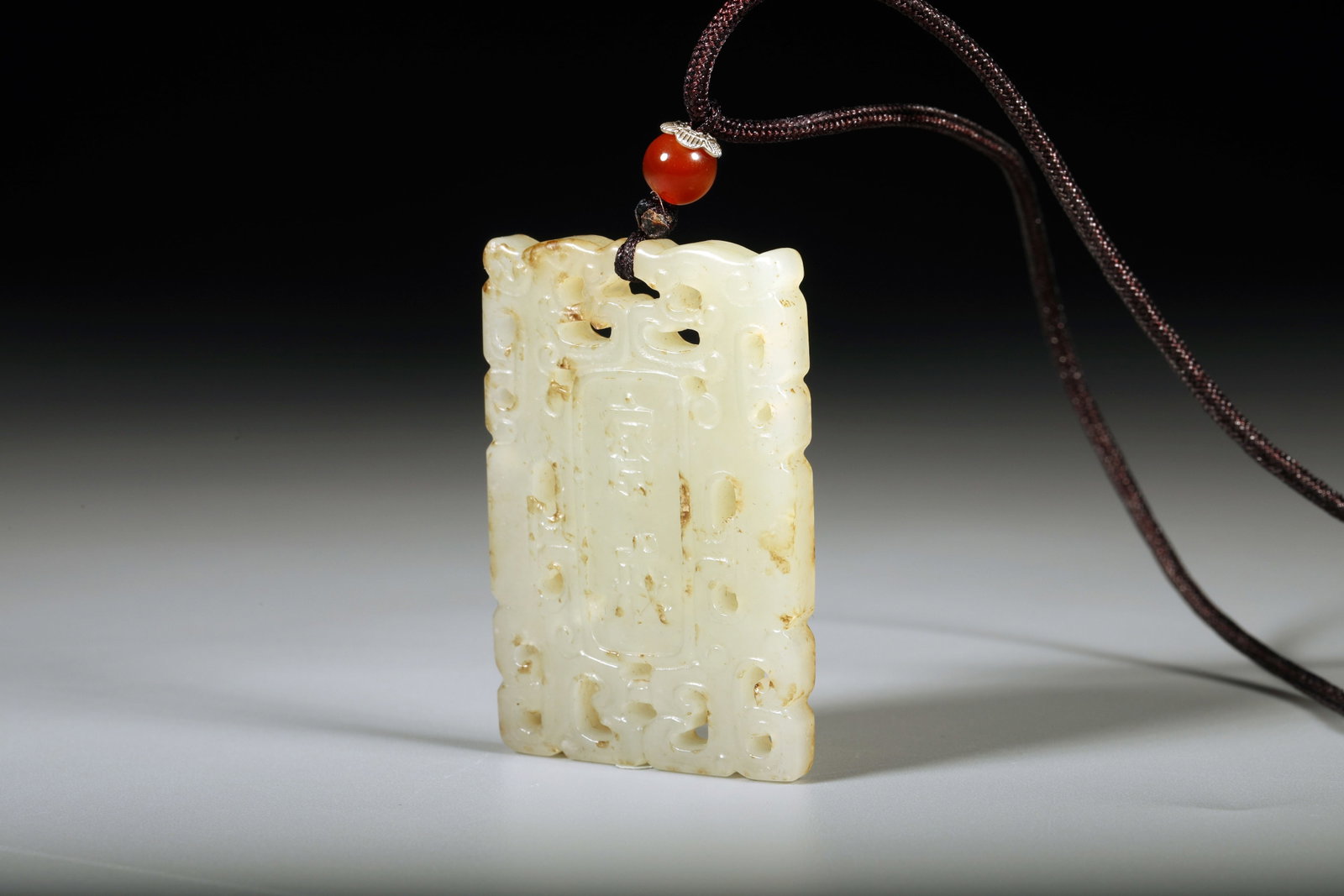A WHITE JADE 'FASTING' PENDANT - 7