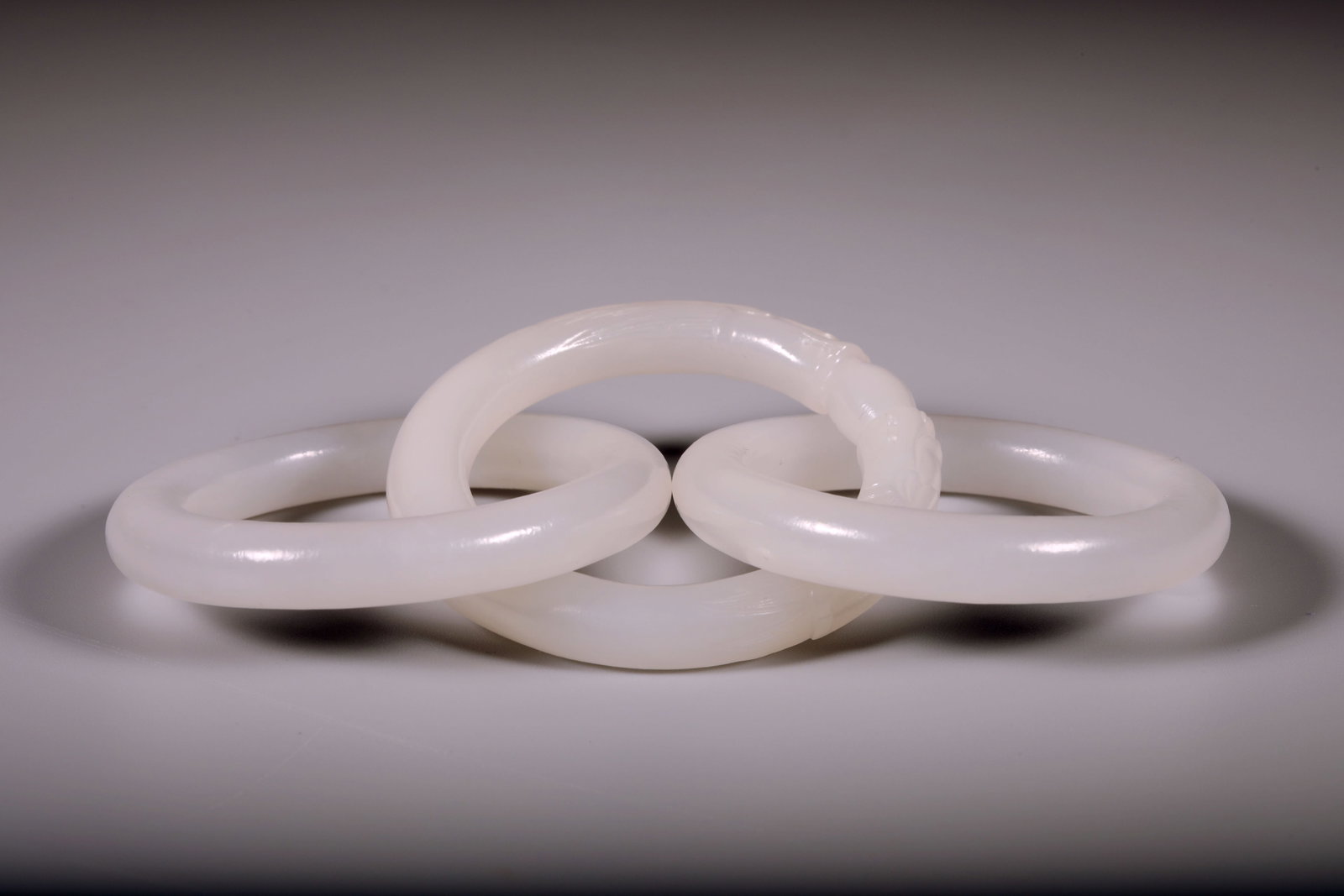 A WHITE JADE 'TWO DRAGONS PLAYING WITH A PEARL' INTERLOCKING RING - 2