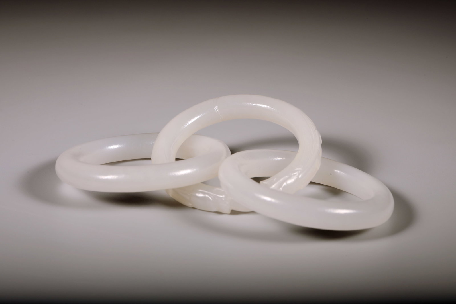 A WHITE JADE 'TWO DRAGONS PLAYING WITH A PEARL' INTERLOCKING RING - 6