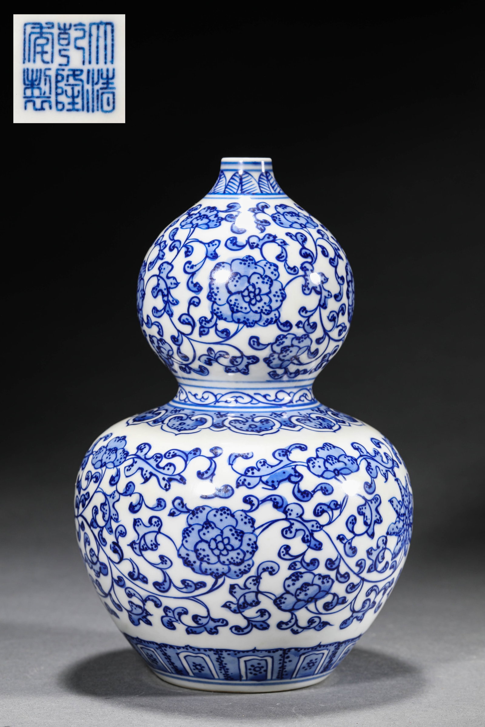 A UNDERGLAZE BLUE GOURD VASE WITH SCROLLING FLORAL MOTIFS: A UNDERGLAZE BLUE GOURD VASE WITH SCROLLING FLORAL MOTIFS Size:Diam:13.5cm,Height:22cm