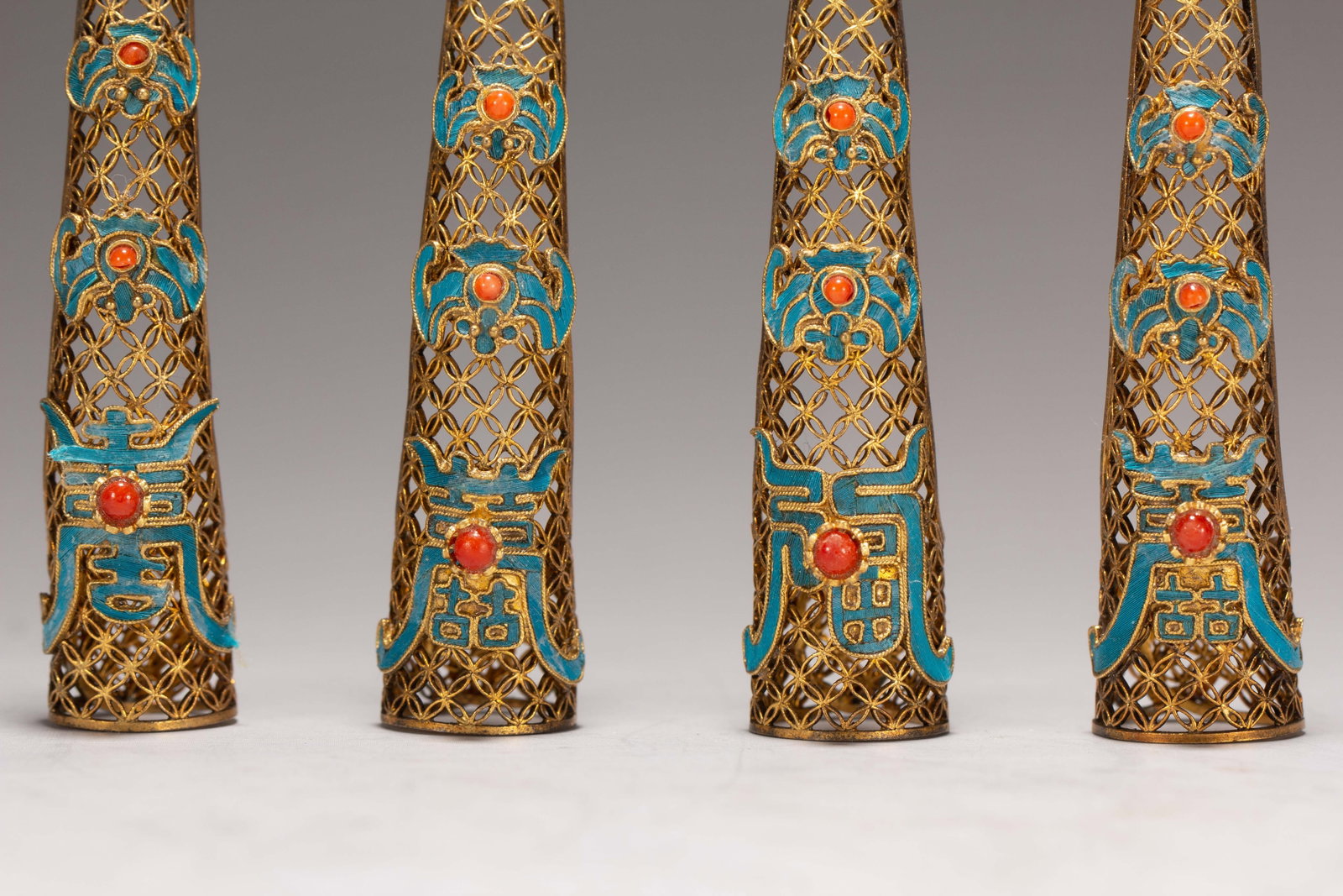 FOUR CHINESE GILT SILVER GEM-SET NAIL GUARDS - 4