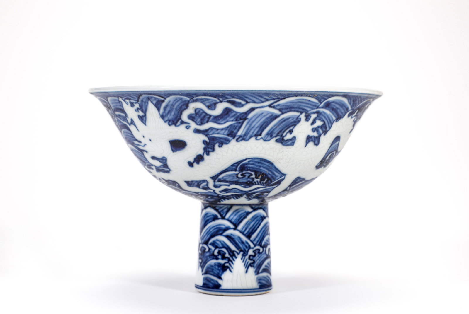 A BLUE AND WHITE RESERVE-DECORATED 'WAVES AND DRAGON' STEM BOWL: A BLUE AND WHITE RESERVE-DECORATED 'WAVES AND DRAGON' STEM BOWL Size:Width:17cm,Height:12cm