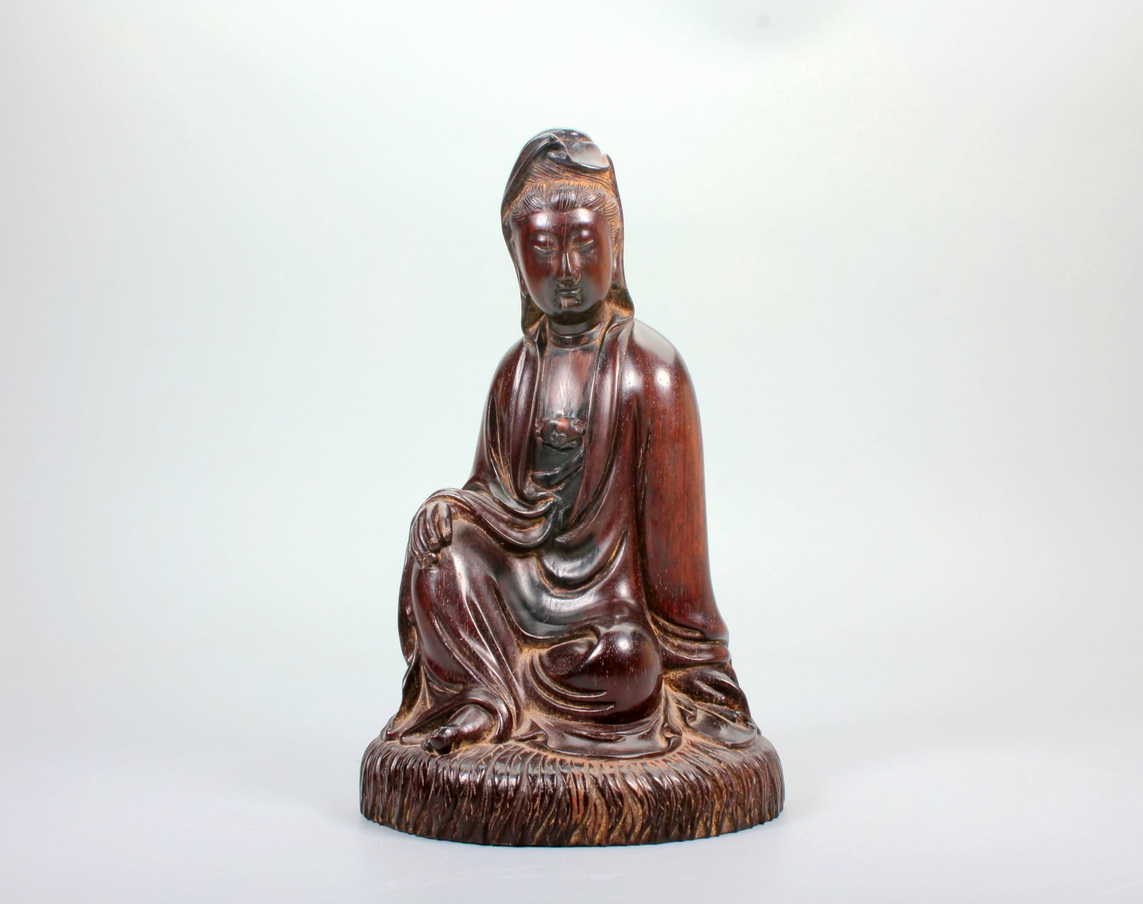 A RED SANDALWOOD CARVED FIGURE OF FREE SEATED GUANYIN: A RED SANDALWOOD CARVED FIGURE OF FREE SEATED GUANYIN Size:Height:18.2cm,Diam:11cm