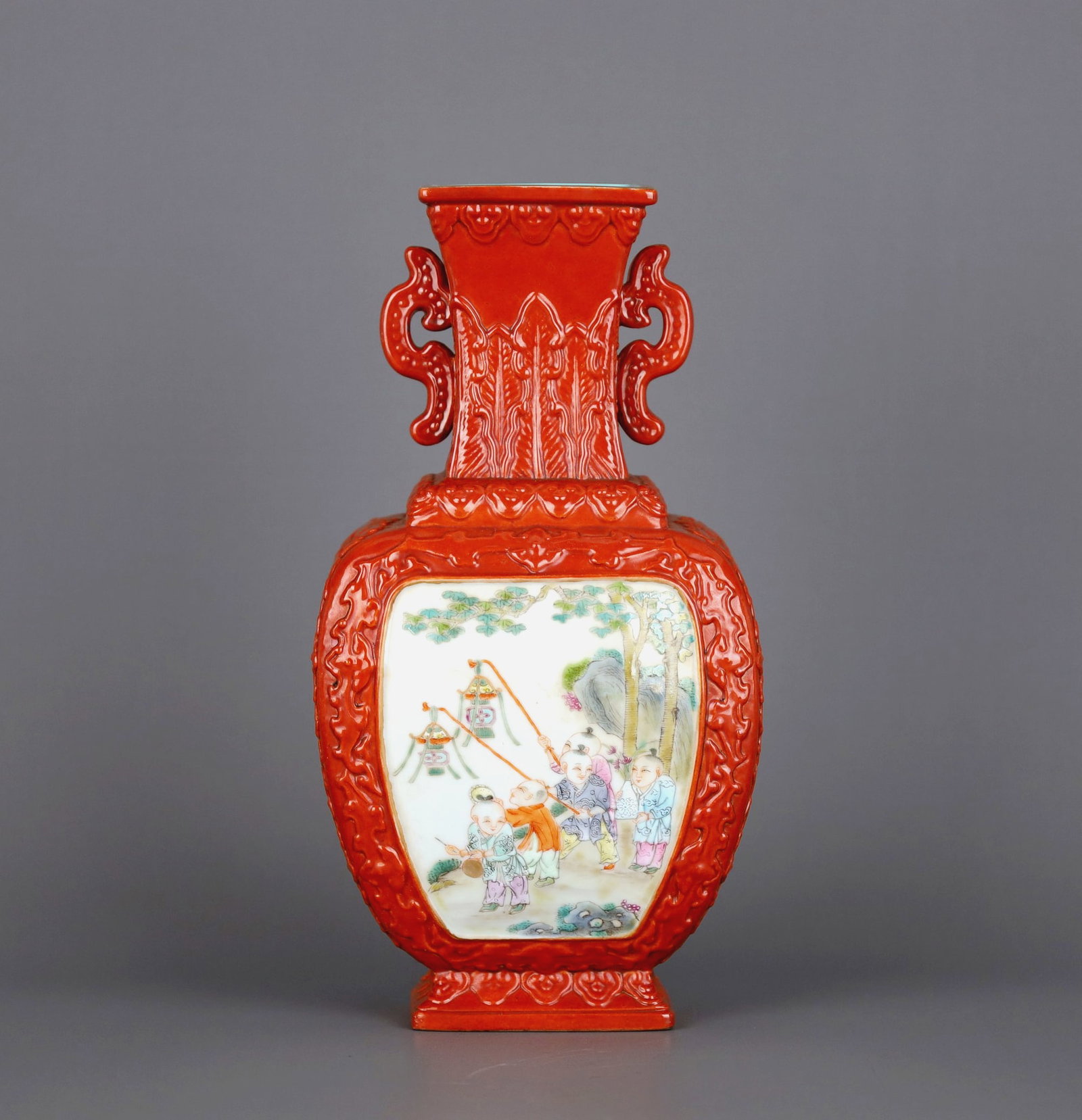 A CORAL-RED-GROUND CARVED 'FIGURES AND BOYS' MEDALLION SQUARE VASE WITH HANDLES: A CORAL-RED-GROUND CARVED 'FIGURES AND BOYS' MEDALLION SQUARE VASE WITH HANDLES Height:20cm,Diam:10.5cm
