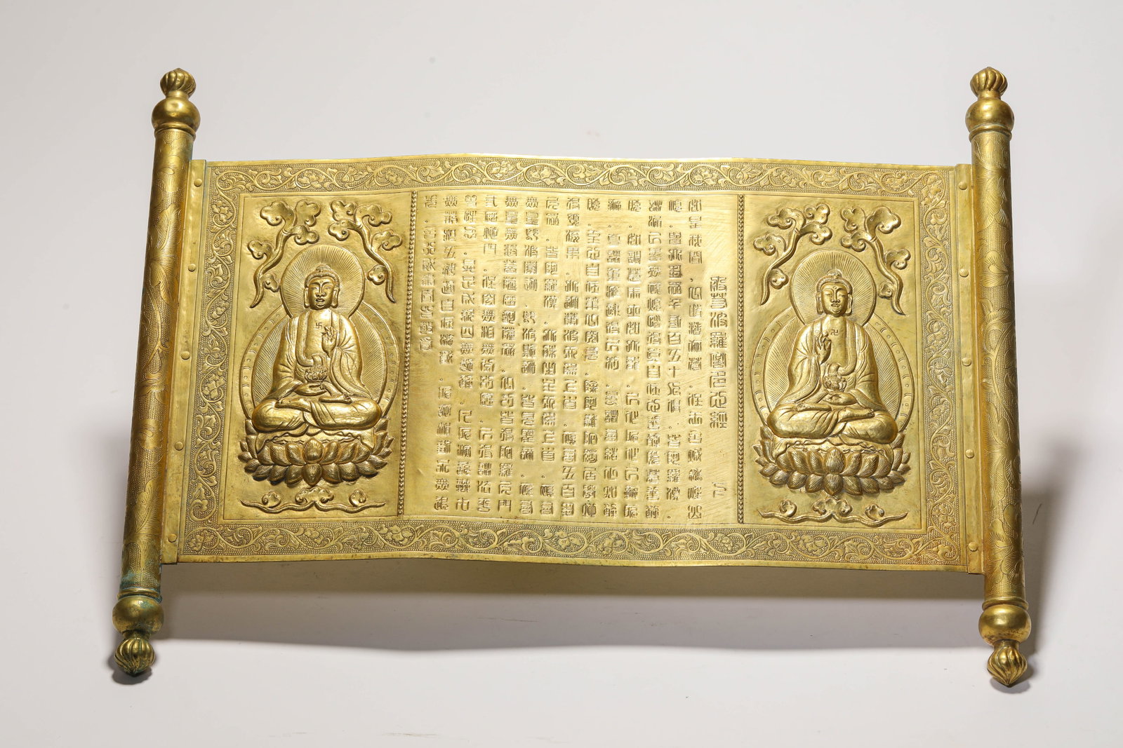 A GILT-BRONZE SUTRA: A GILT-BRONZE SUTRA Description: Dimensions: Weight: 527 g. Width: 35.8 cm x Height: 27.5 cm. All measurements are approximate.