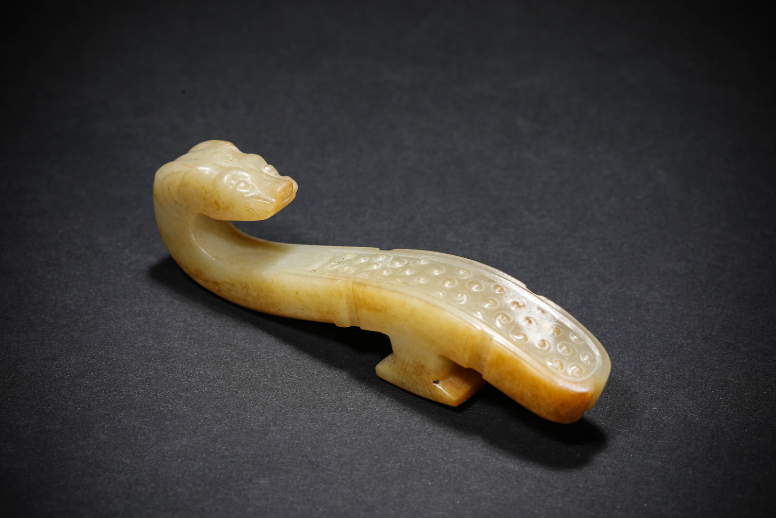 A JADE 'CARVED DRAGON' BELT HOOK: A JADE 'CARVED DRAGON' BELT HOOK Description: Dimensions: Length: 10.5 cm x Width: 1.9 cm x Height: 2.4 cm. All measurements are approximate.