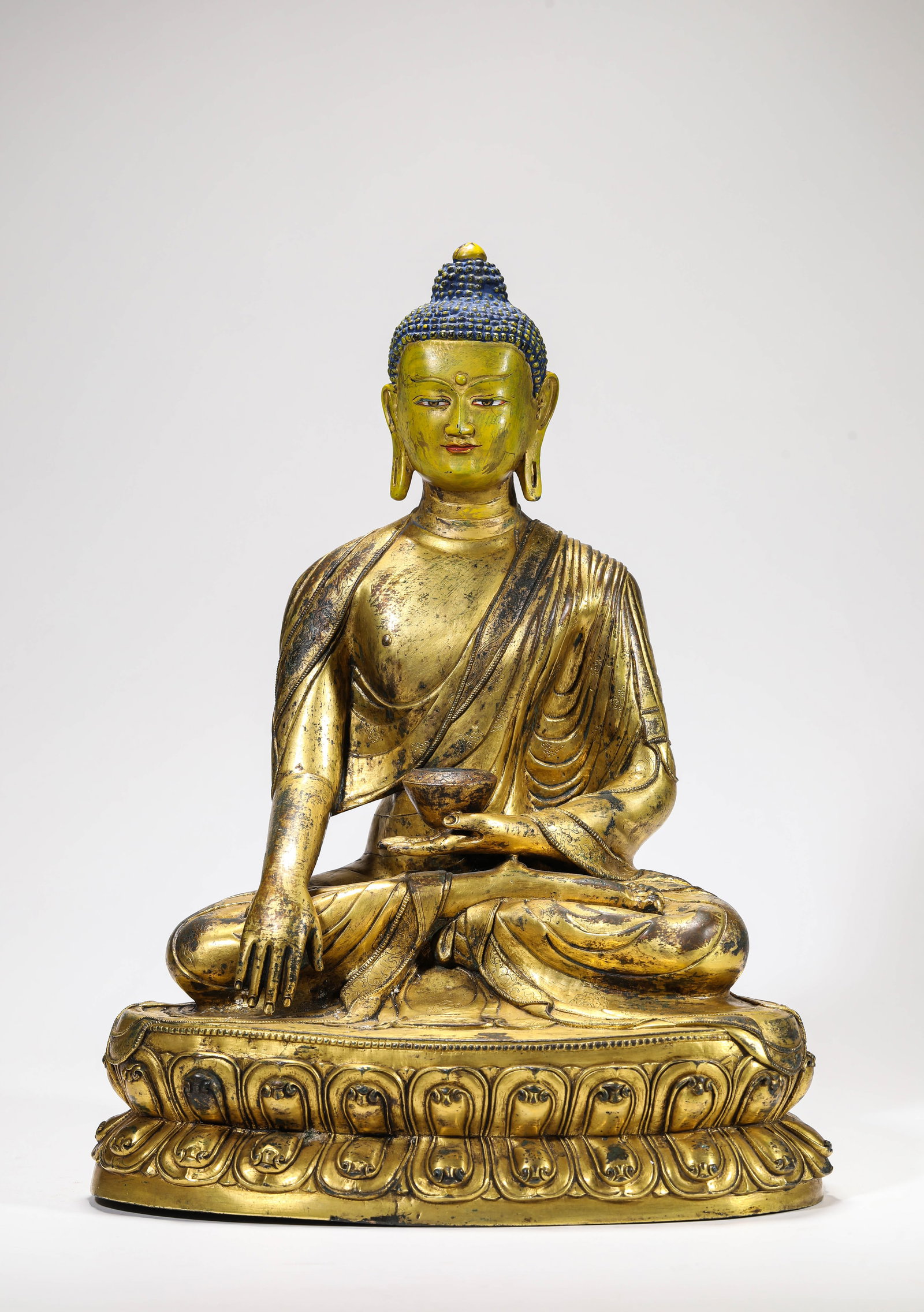 A GILT-BRONZE FIGURE OF SHAKYAMUNI: A GILT-BRONZE FIGURE OF SHAKYAMUNI Description: Dimensions: Weight: 11300 g. Length: 29.5 cm x Width: 21.2 cm x Height: 39 cm. All measurements are approximate.