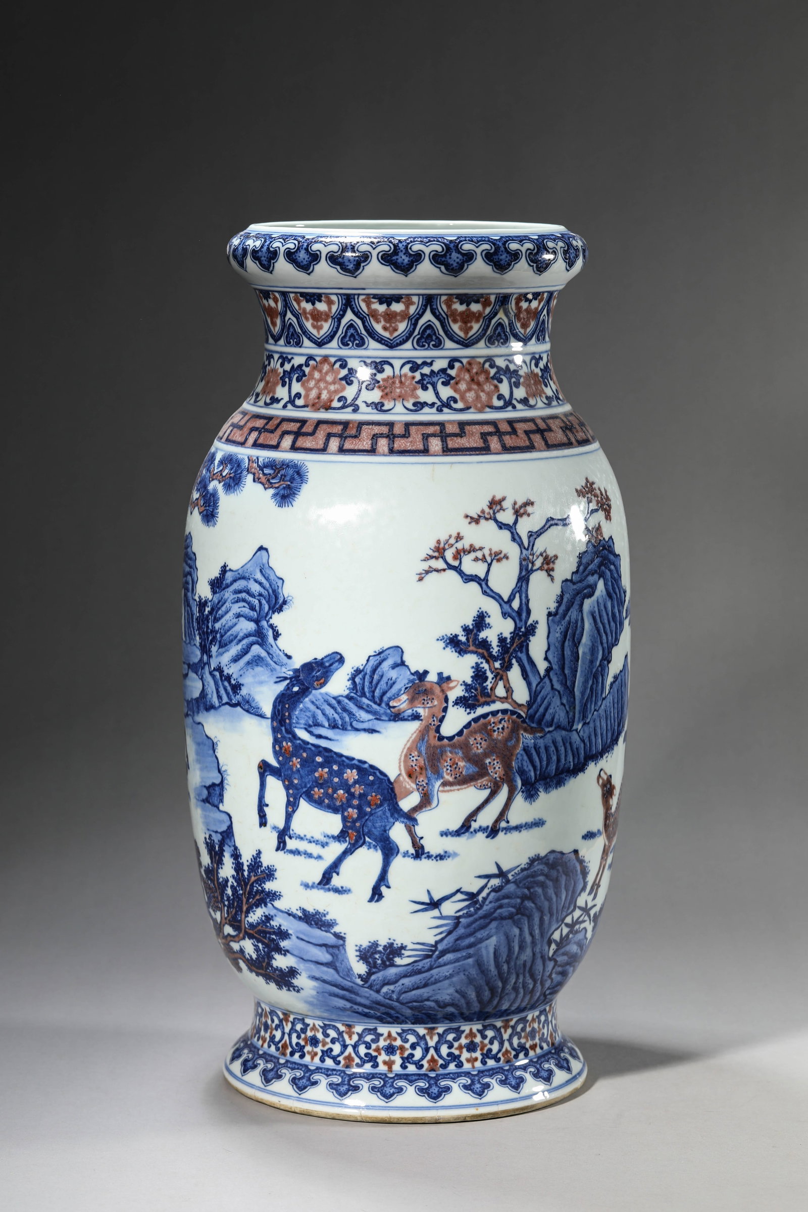 A BLUE AND WHITE AND UNDERGLAZE-RED 'PINE, DEER AND SPRING' LANTERN ZUN: A BLUE AND WHITE AND UNDERGLAZE-RED 'PINE, DEER AND SPRING' LANTERN ZUN Description: Dimensions: Width: 23.3 cm x Height: 46.2 cm. All measurements are approximate.