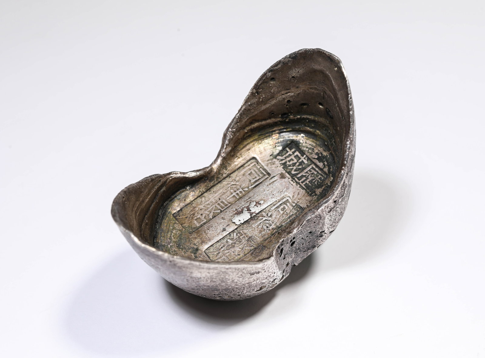 A SILVER INGOT: A SILVER INGOT Description: Dimensions: Weight: 370 g. Length: 7.4 cm x Width: 4.3 cm x Height: 5 cm. All measurements are approximate.