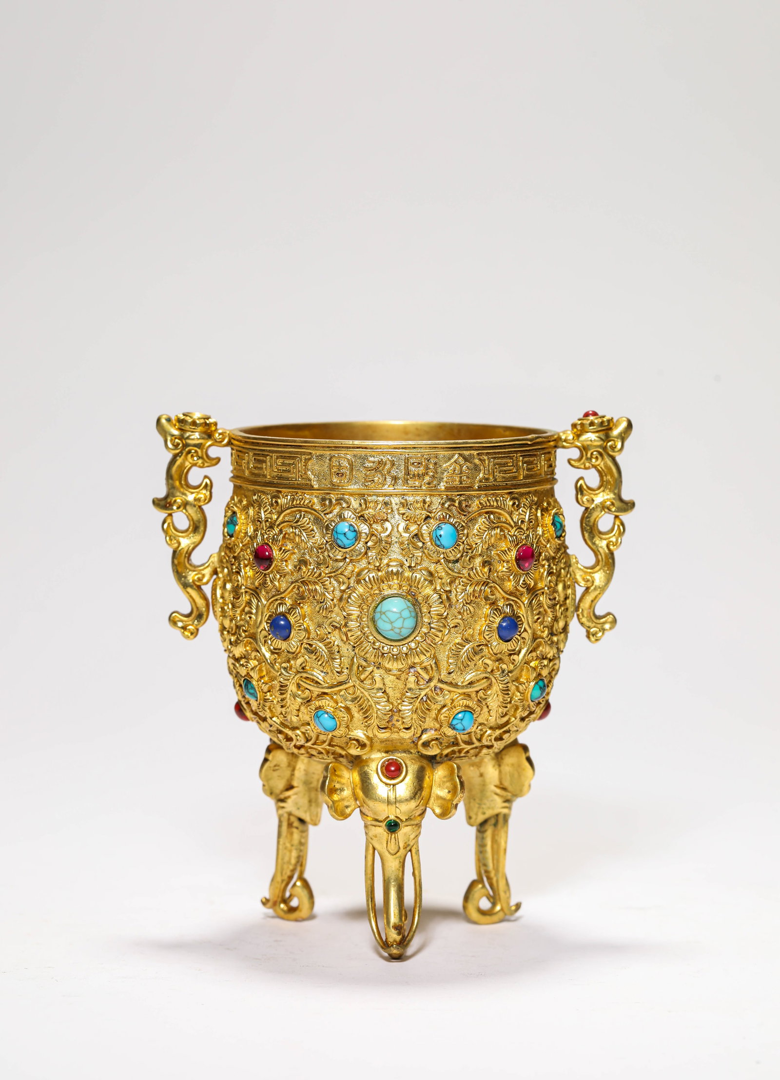 A GILT-BRONZE AND GEM-SET CUP: A GILT-BRONZE AND GEM-SET CUP Description: Dimensions: Weight: 524 g. Length: 11.8 cm x Width: 9.5 cm x Height: 13 cm. All measurements are approximate.