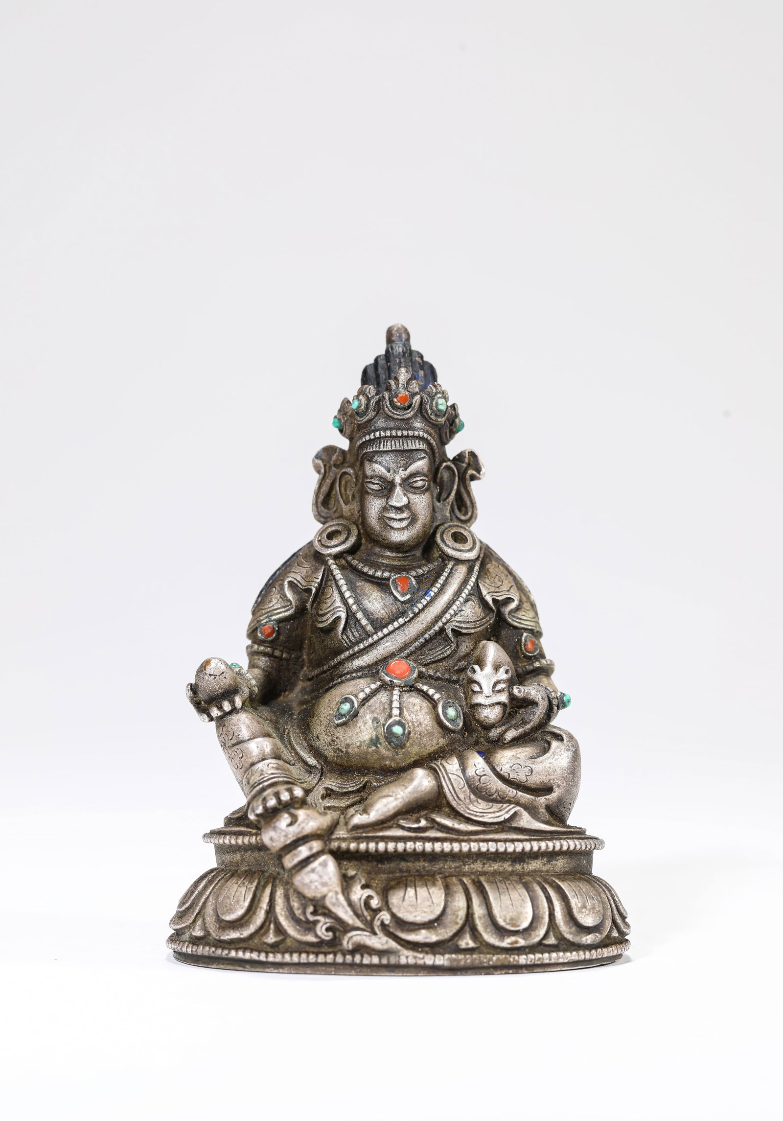 A SILVER FIGURE OF A JAMBHALA: A SILVER FIGURE OF A JAMBHALA Description: Dimensions: Weight: 351 g. Length: 6.6 cm x Width: 5.1 cm x Height: 9.1 cm. All measurements are approximate.