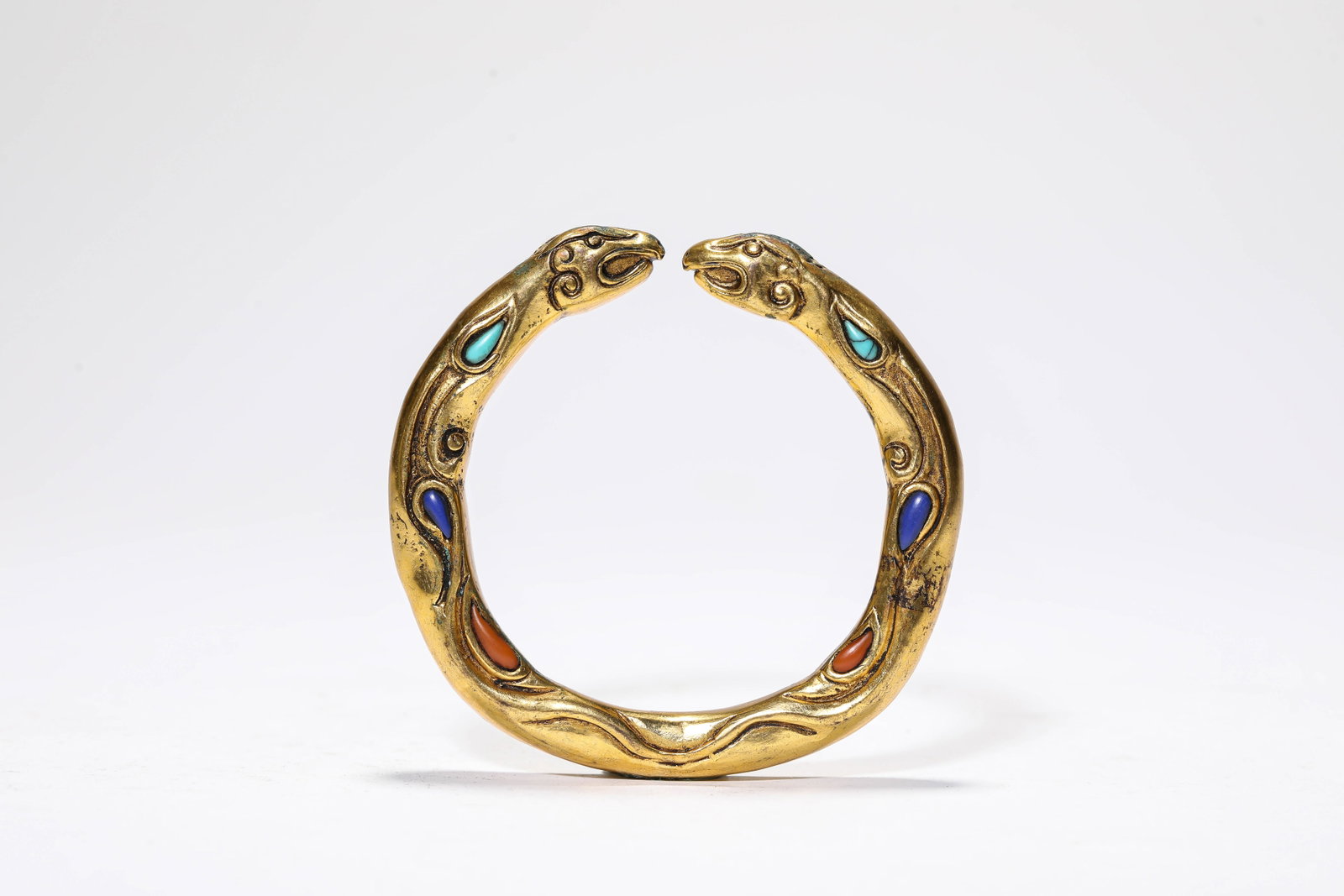 A GILT-BRONZE AND GEM-SET BRACELET: A GILT-BRONZE AND GEM-SET BRACELET Description: Dimensions: Weight: 141 g. Width: 57 cm. All measurements are approximate.