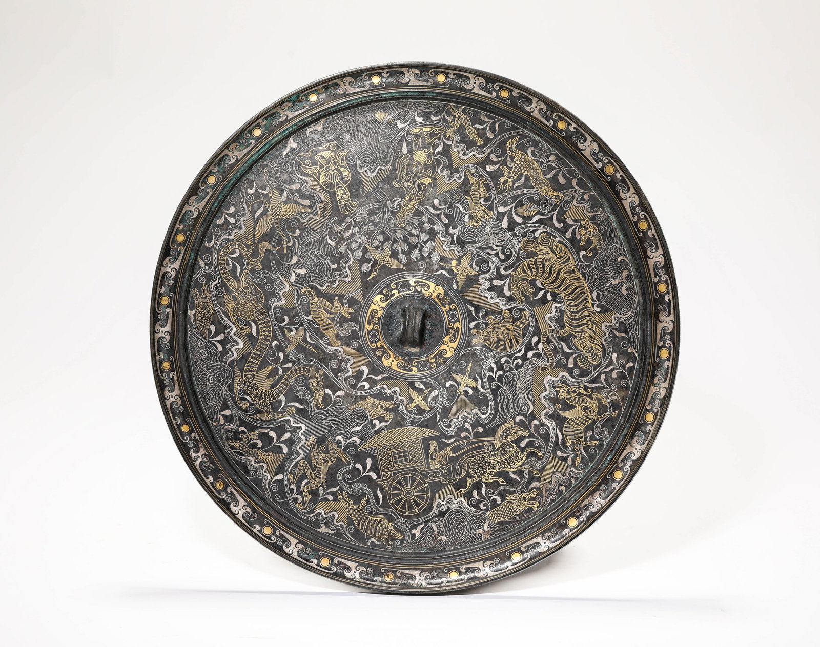 A GOLD AND SILVER-INLAID BRONZE 'NARRATIVE SCENE' MIRROR: A GOLD AND SILVER-INLAID BRONZE 'NARRATIVE SCENE' MIRROR Description: Dimensions: Weight: 1852 g. Width: 28.5 cm. All measurements are approximate.