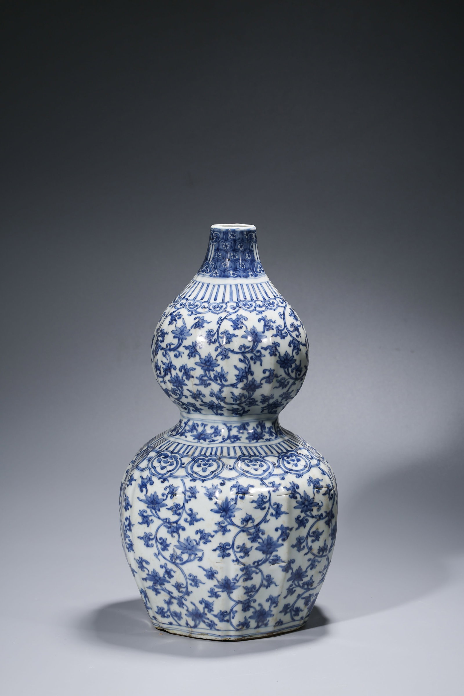 A BLUE AND WHITE 'INTERLOCKING FLORALS' 'DOUBLE-GOURD' VASE: A BLUE AND WHITE 'INTERLOCKING FLORALS' 'DOUBLE-GOURD' VASE Description: Dimensions: Width: 25.7 cm x Height: 45.1 cm. All measurements are approximate.