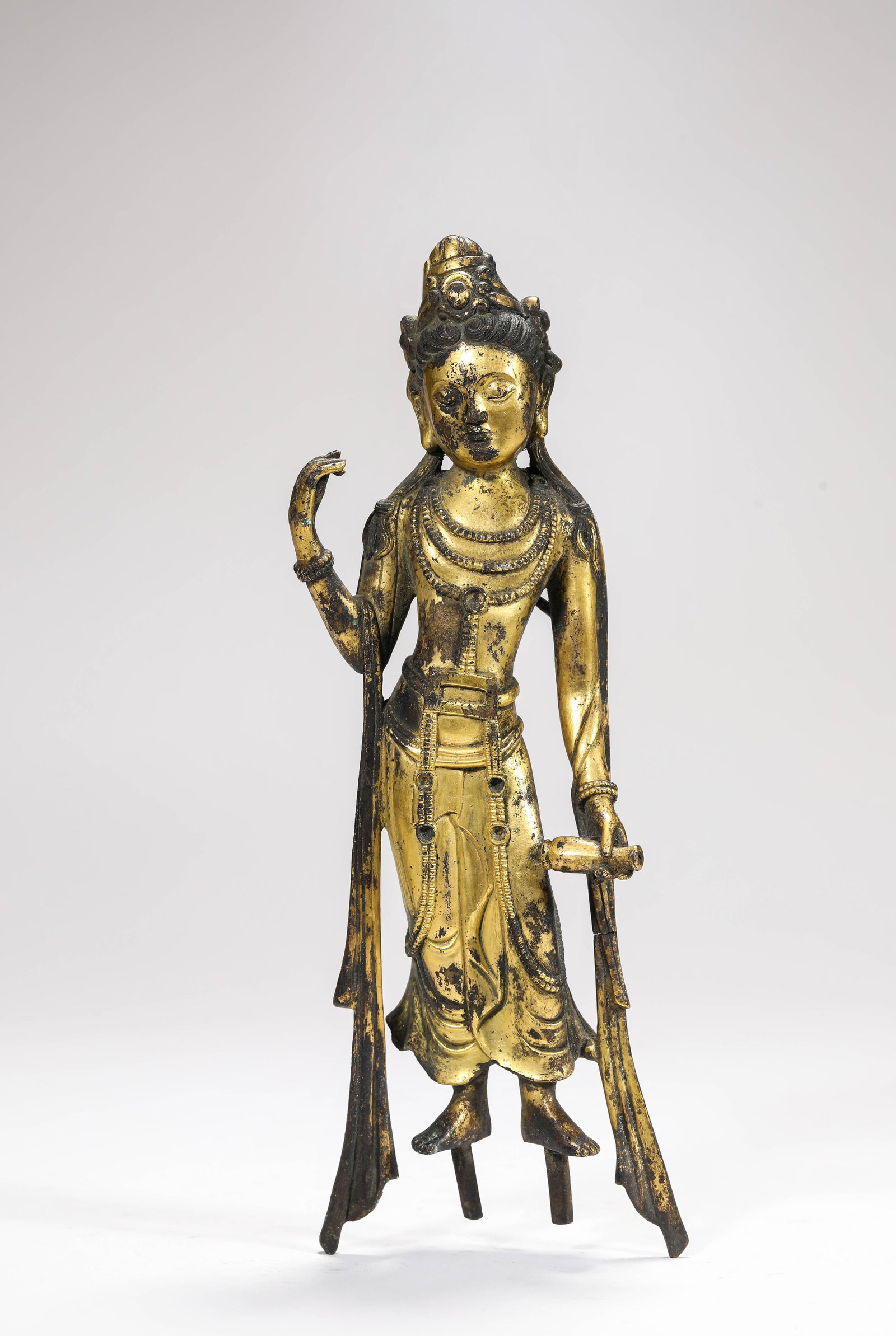 A GILT-BRONZE 'KUNDIKA-HOLDING' FIGURE OF AVALOKITESHVARA: A GILT-BRONZE 'KUNDIKA-HOLDING' FIGURE OF AVALOKITESHVARA Description: Dimensions: Weight: 1200 g. Length: 10 cm x Width: 3.6 cm x Height: 28 cm. All measurements are approximate.