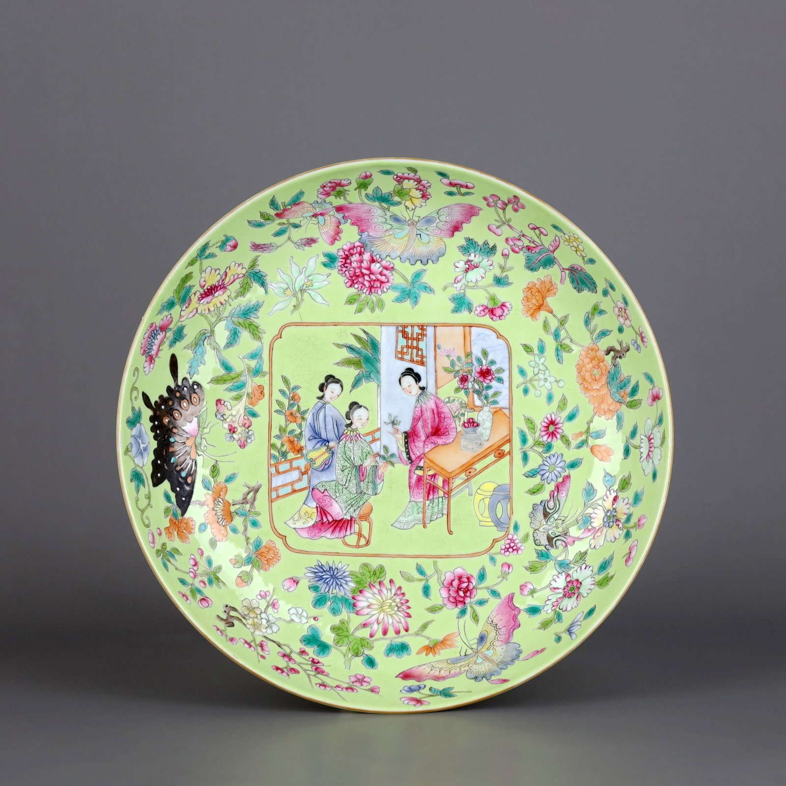 A GREEN-GROUND FAMILLE ROSE DISH WITH BUTTERFLY AND LADY PATTERN: A GREEN-GROUND FAMILLE ROSE DISH WITH BUTTERFLY AND LADY PATTERN Height:4.3cm,Diam:21.5cm