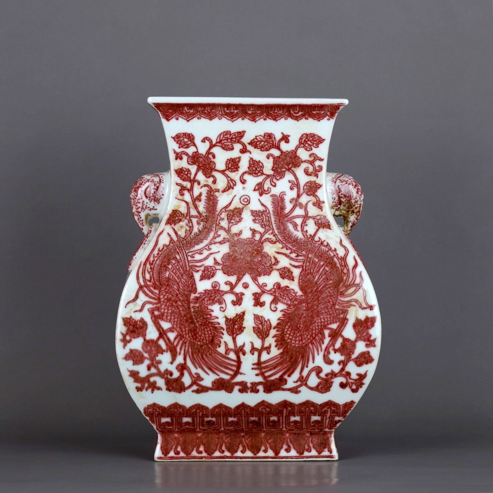 A UNDERGLAZE COPPER-RED SQUARE VASE WITH PEONY, DOUBLE PHOENIX AND ELEPHANT-HANDLES: A UNDERGLAZE COPPER-RED SQUARE VASE WITH PEONY, DOUBLE PHOENIX AND ELEPHANT-HANDLES Height:27cm,Diam:19.5cm