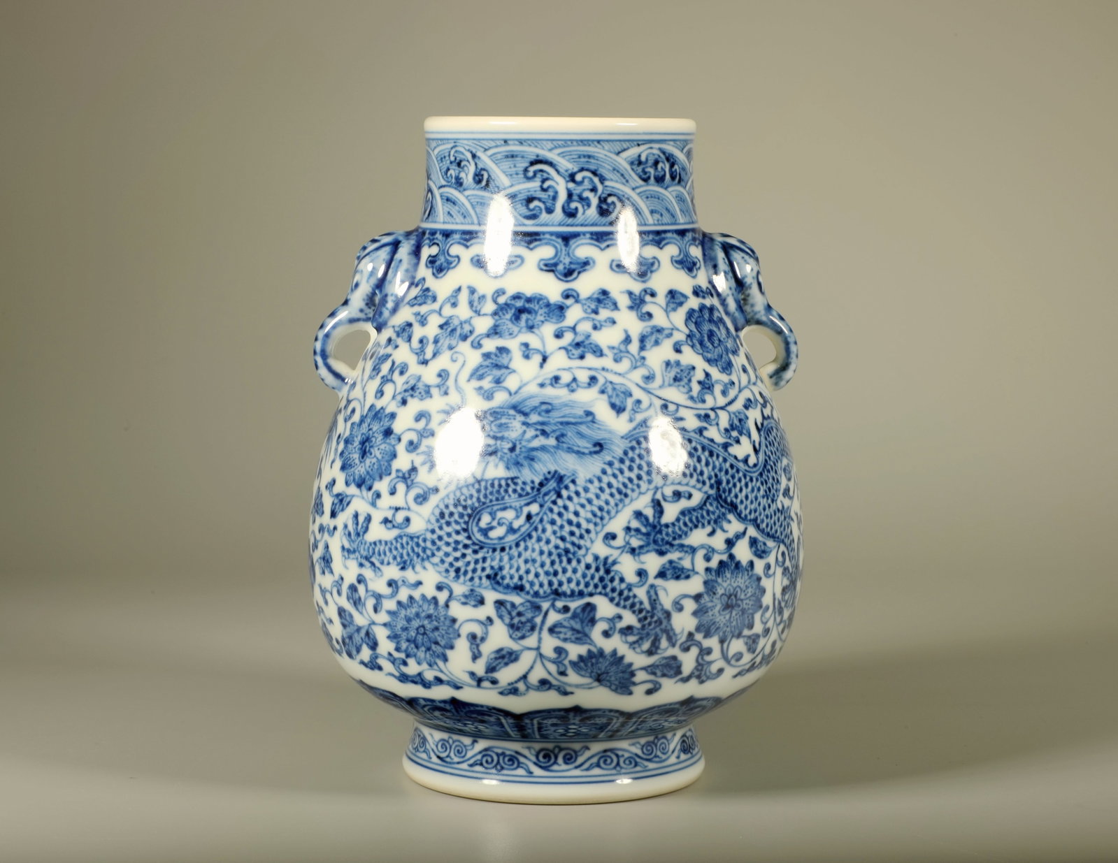 A BLUE AND WHITE DRAGON ELEPHANT-EARED ZUN VASE: A BLUE AND WHITE DRAGON ELEPHANT-EARED ZUN VASE Height:15.5cm,Diam:11cm