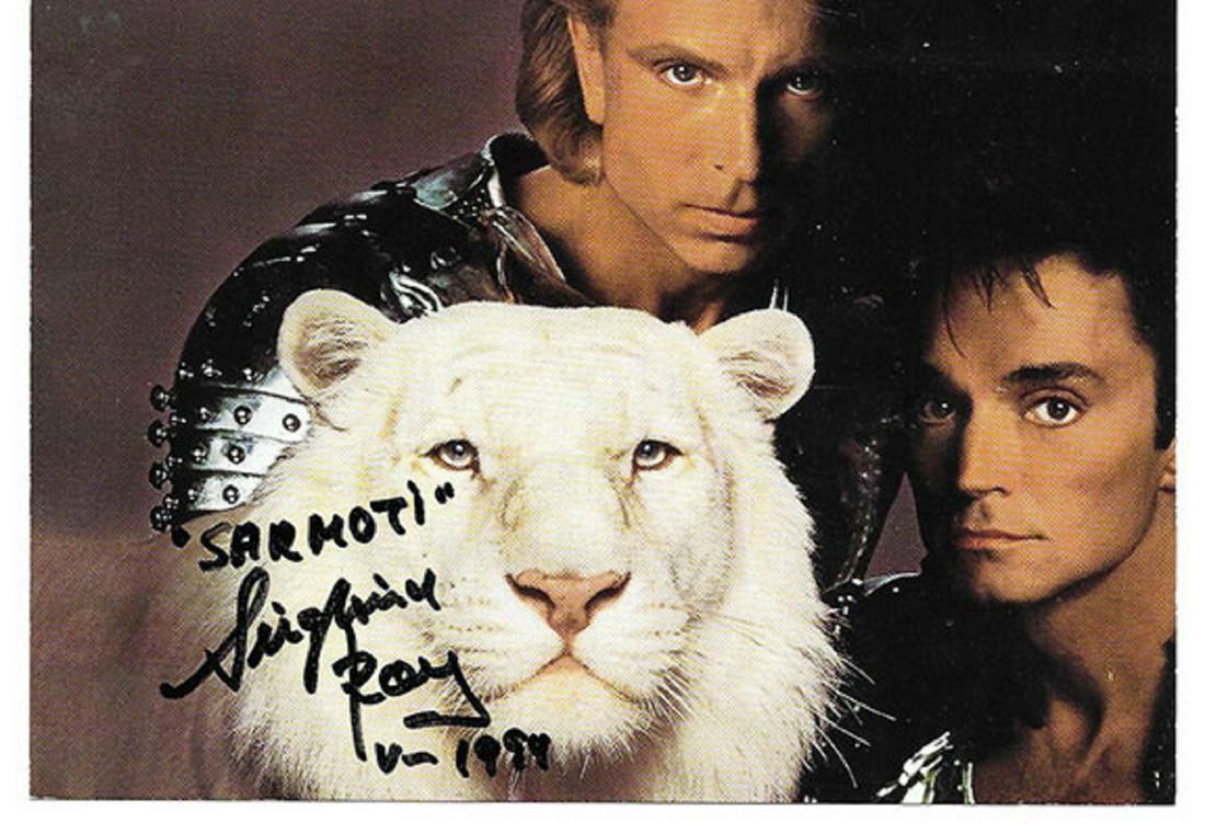 Siegfried and Roy signed photo: Color photograph, 5”x7” from the Mirage in Las Vegas. Siegfried and Roy are posing with Sitarra, one of their Royal White Tigers. Boldly signed "Sarmoti, Siegfried/Roy 1994". In excellent