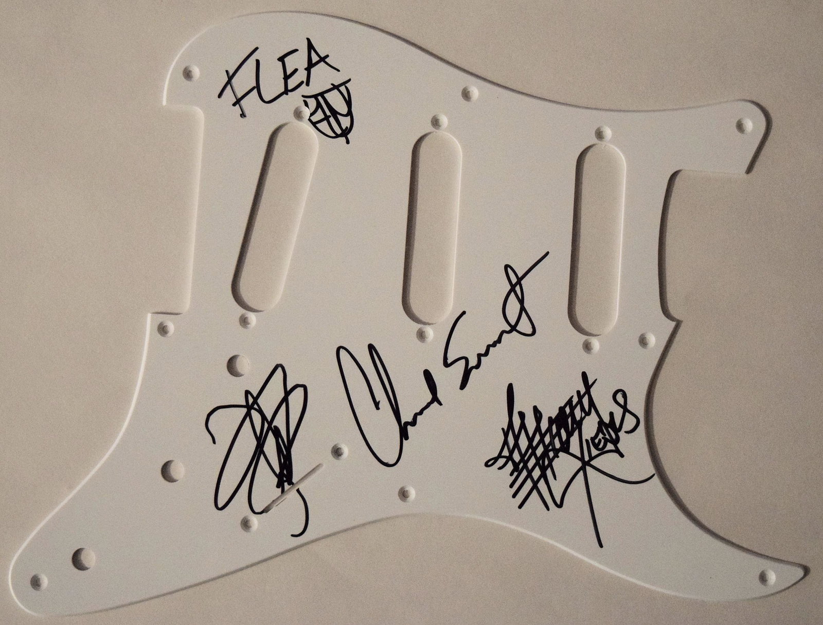 Red Hot Chili Peppers signed Pick Guard: Red Hot Chili Peppers signed White Fender Strat Pick Guard Signed Anthony Kiedis, John Frusciante, Flea, and Chad Smith.