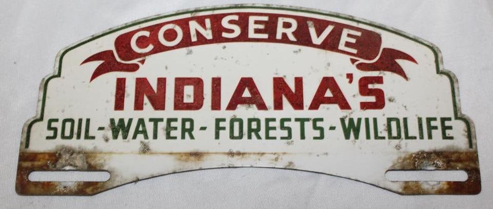 Indiana Conserve License Plate Topper Sign: has reflective paint and light rust staining throughout, slightly heavier rust near the mounting holes, 10" x 4.5"
