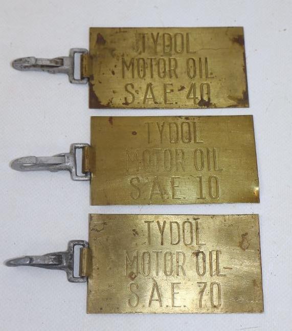 COLLECTION OF 3: TYDOL MOTOR OILS STAMPED BRASS OIL BARREL TAGS WITH ORIGINAL CLIPS.: 3.5" X 2" EACH. 1930'S BRASS TAGS EACH SHOWING TYDOL MOTOR OIL STAMPED INTO THE FACE AS WELL AS THE OIL GRADE. EACH TAG SHOWS ORIGINAL CLIPS USED FOR HANGING FROM OIL BARRELS. CONDITION: ORIGINAL AND 