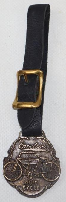 EXCELSIOR MOTORCYCLES ADVERTISING WATCH FOB.: FOB 1.5" X 1.5". BRASS ADVERTISING WATCH FOB FRO EXCELSIOR MOTORCYCLES SHOWING EARLY MOTORCYCLE GRAPHIC. CONDITION: OVERALL EXCELLENT SHOWING NO NOTABLE DAMAGE ON EITHER SIDE WITH A NEW LEATHER BAND.