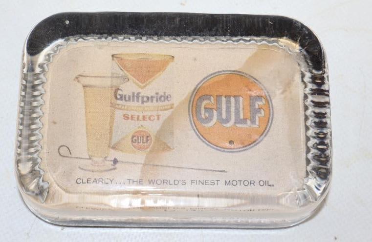 GULF GULFPRIDE MOTOR OILS SERVICE STATION ADVERTISING PAPER WEIGHT.: 4" X 3". 1960'S ADVERTISING PAPERWEIGHT FOR GULF SHOWING QUART CAN GRAPHIC. CONDITION: OVERALL VERY GOOD SHOWING NO CHIPPING IN THE GLASS WITH ORIGINAL FELT ATTACHED AT THE BOTTOM. GRAPHIC SHOWS LIGHT