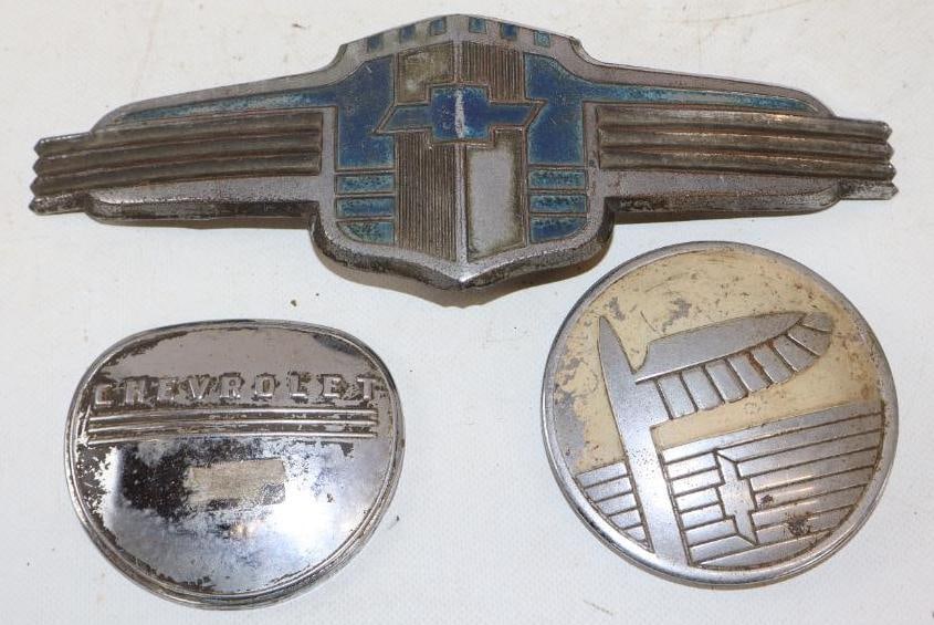 Group of 3 1940's Chevrolet Horn Buttons And Grill Emblem: largest is 10" x 3.25"