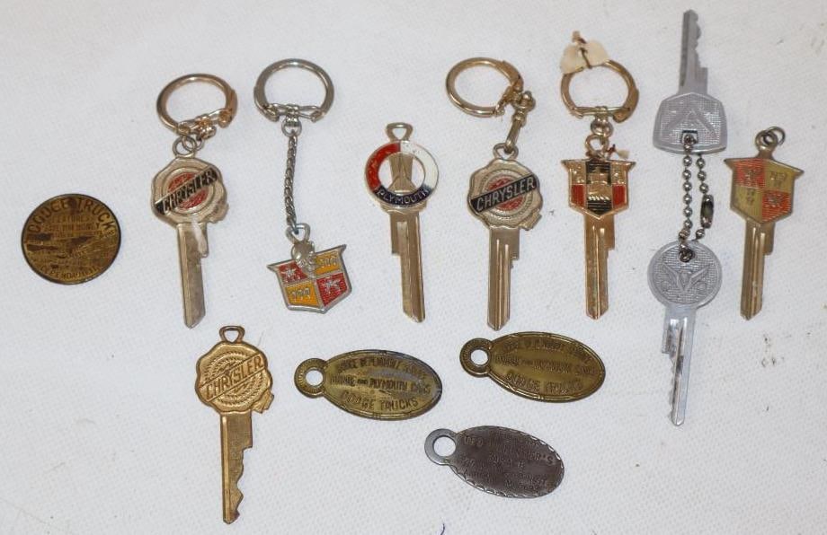 Group of 13 Chrysler and DeSoto Keys and Keychains: largest 4" x 1"