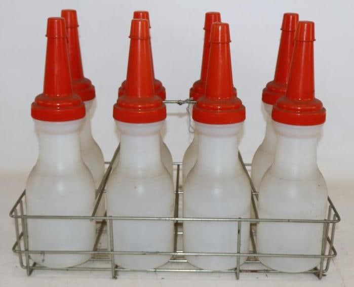 Group of 8 Plastic Bulk Oil Bottles with Carrying Rack: All bottles are unbranded and have lids. One lid is cracked. 18" x 9" x 14"