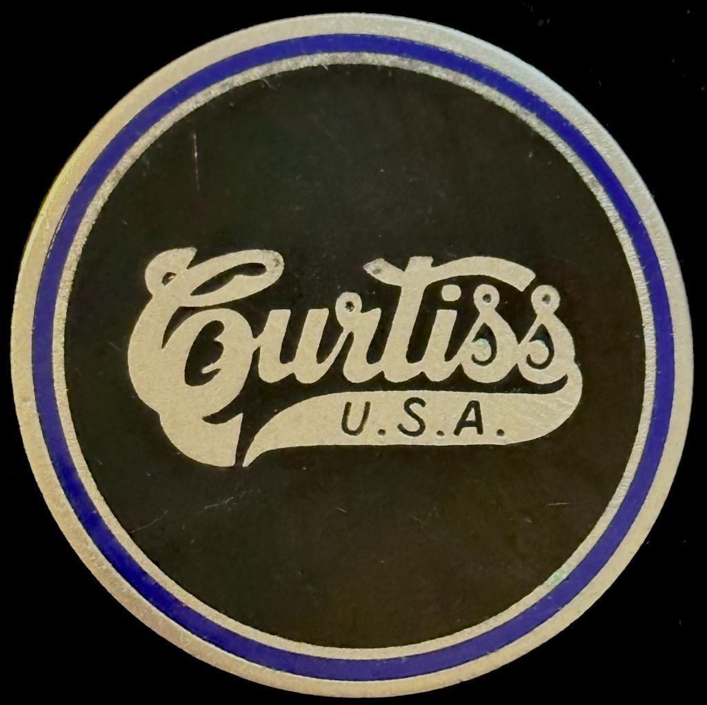 Curtiss Emblem: Curtiss emblem from the Shears Collection. It is pictured on www.americanautoemblems.com. It's believed to be from an airplane. It has a Fox maker's mark and measures approximately 2" in diameter.
