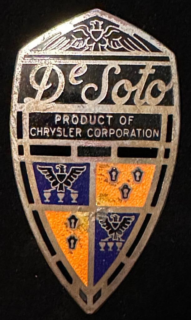 DeSoto Radiator Emblem: 1935 - 1936 DeSoto radiator emblem. It has an AD Seal maker's mark. It measures approximately 3.5" high by 2" wide.