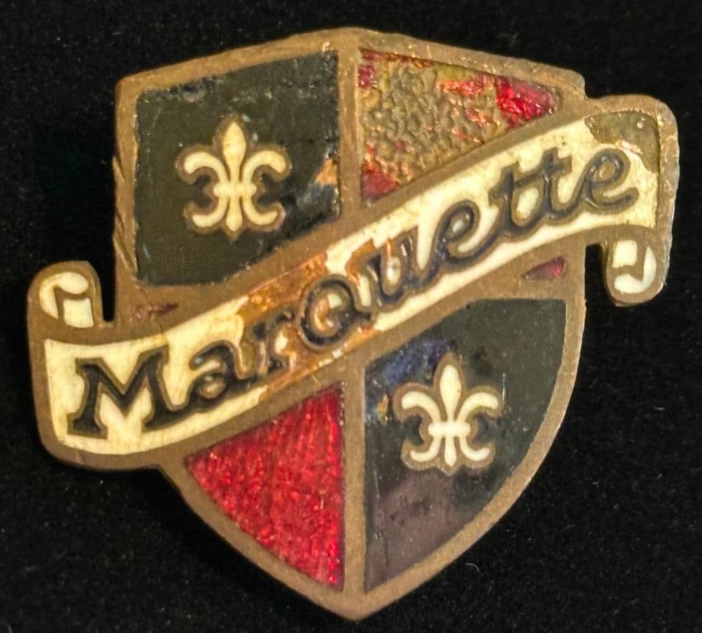 Marquette Radiator Emblem: 1930 Marquette radiator emblem. It has a Fox maker's mark and measures approximately 1.25" wide by 1.1" high.