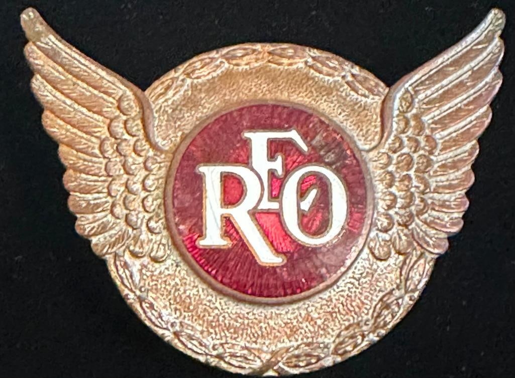 REO Radiator Emblem: 1927 - 1930 REO radiator emblem. It measures approximately 2.75" wide by 2.25" high.