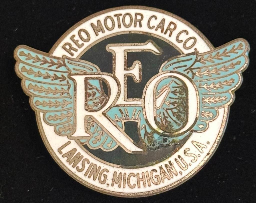 REO Radiator Emblem: 1920 - 1926 REO radiator emblem. It has a DL Auld maker's mark and measures approximately 2.5" wide by 2." high.