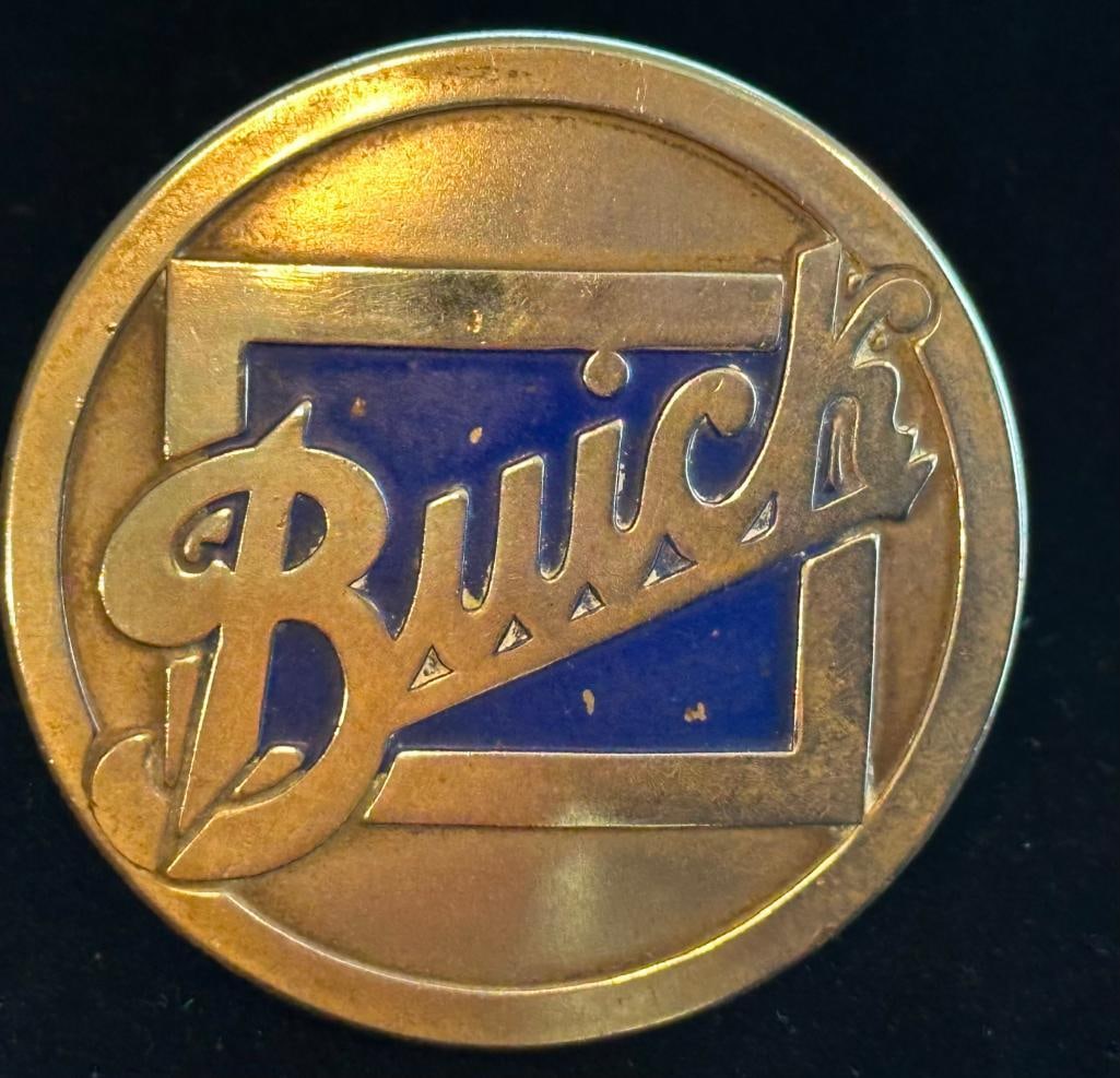 1920's Buick Wheel Hub Emblem: 1920's Buick Wheel Hub Emblem. This emblem has a DL Auld maker's mark and measures approximately 2.5" in diameter.