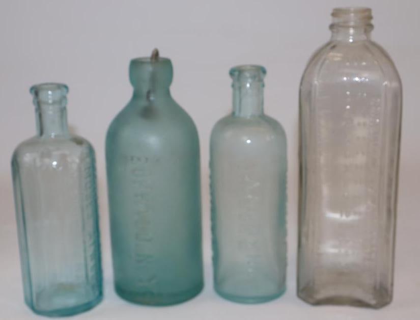 Group of 4 Embossed Glass Advertising Bottles; Champion, Liniment, Atwoods, and Young & Co "Blob (1 of 2)