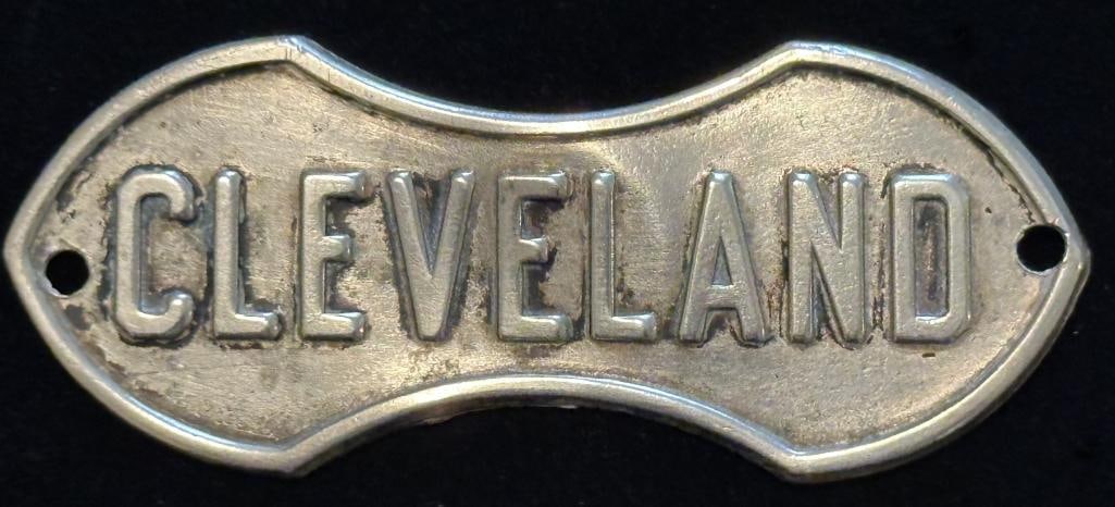 Cleveland Radiator Emblem: 1919 - 1926 Cleveland radiator emblem. This emblem measures approximately 2.9" wide by 1.2" high. The holes are not original.