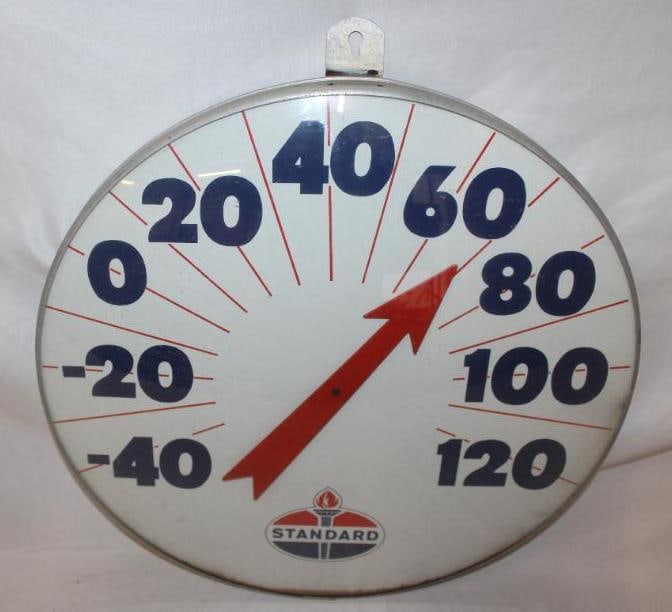 Large Standard Oil Company Advertising Thermometer: This thermometer is in working condition and has a glass outer face. There is some rust staining along the bottom edge of the dial. The thermometer measures 12" x 12" and is graded an 8.25.