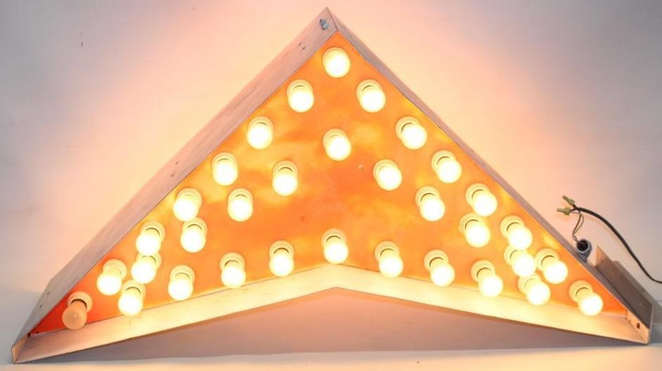 Flashing Arrow Lighted Light Bulb Sign: This arrow sign is in an aluminum housing. It lights up and works on both sides. There is some discoloration to the orange background on one side. The sign measures 48" x 23" x 12".