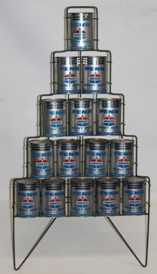 Group of 15 Penn Amoco HD One Quart Oil Cans with Pyramidal Display Rack: All of the metal oil cans are drained from two holes in the top. The cans are in various conditions with minor wear and dents. The overall measurements of this display are 22.5" x 19.5" x 38.5".