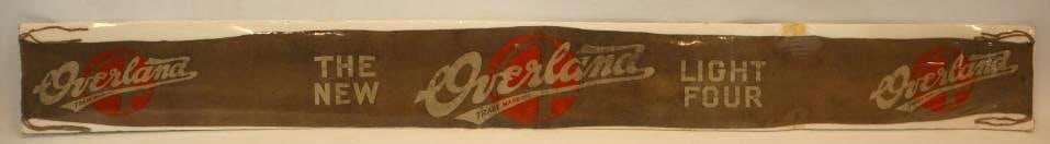1910's Overland Light Four Felt Dealership Banner: This banner is displayed with shrink wrap over a foam board backing. This is a great early dealership banner advertising the Overland Four. It does have some discoloration throughout and some light st