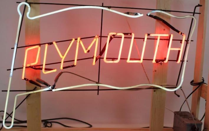 Plymouth Dealership Flag Shaped Pink and White Neon Light Up Sign: This neon is in good working condition. The new wood crate measures 54" x 12" x 38.25". The neon itself measures 43" x 32".