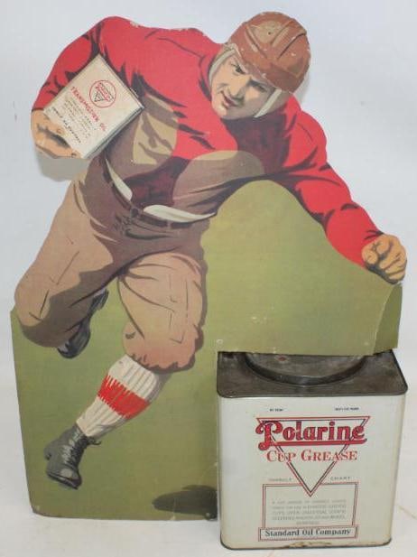 1920's Polarine Football Player Die Cut Cardboard Display with 25lb Grease Can: The cardboard display has some bends near the outer edges and at the top. It also has some slight staining throughout the field. The bottom of the display appears to be trimmed and the opening for the