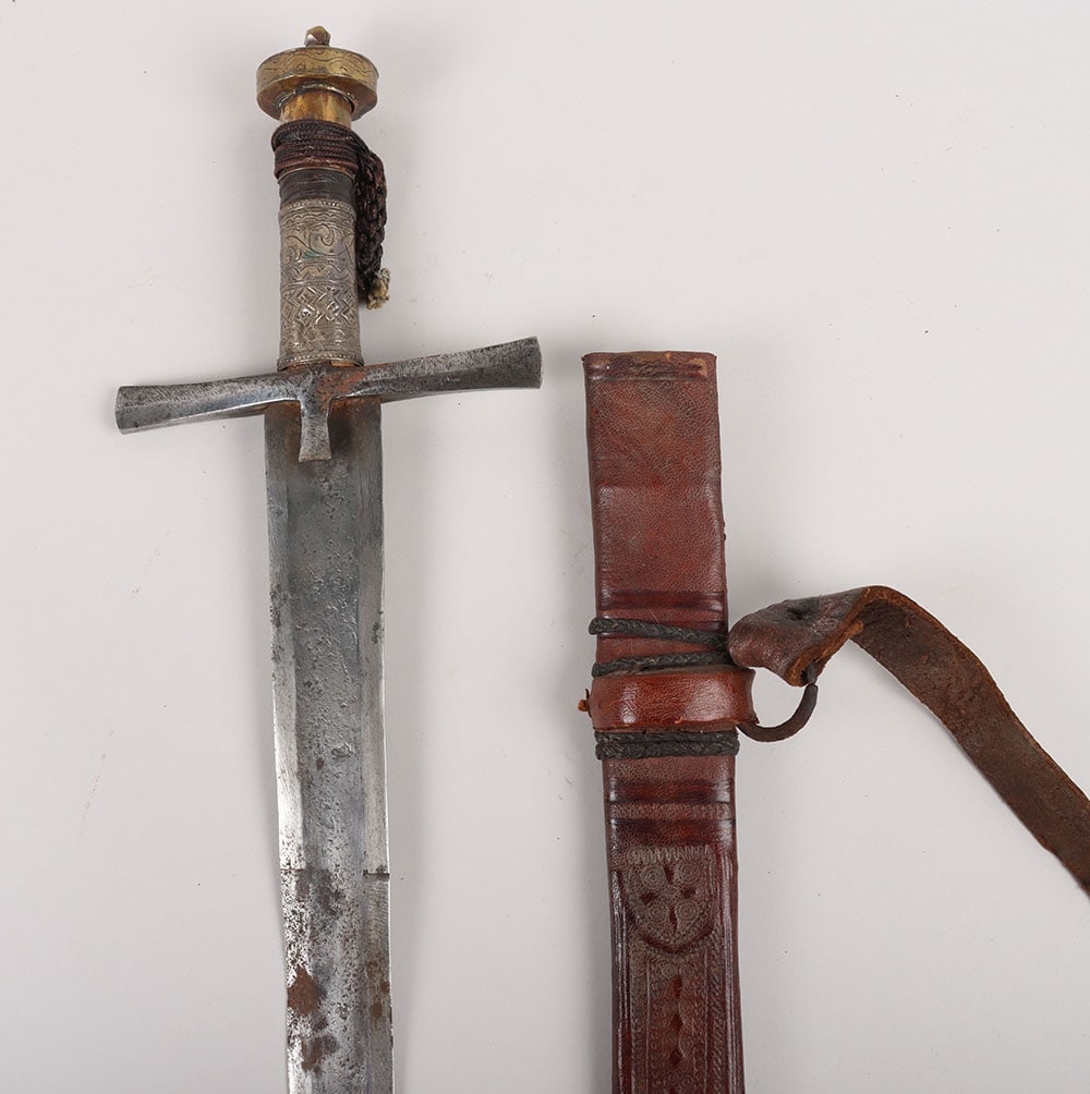 Sudanese Mahdist Period Sword Kaskara,: Sudanese Mahdist Period Sword Kaskara , broad straight double edge blade 83cms, iron crosspiece, grip with sheet silver cover engraved with geometric designs, brass pommel also engraved with geometric