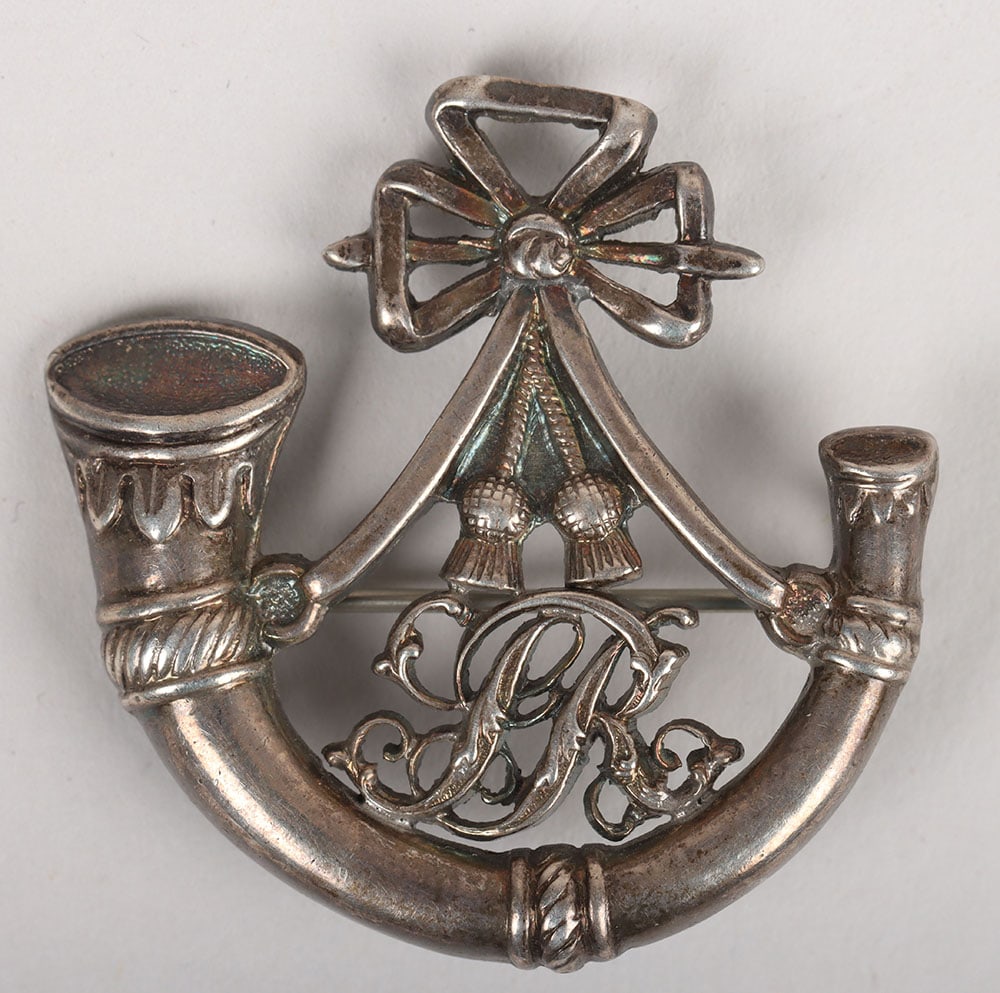‘SR’ Hat Badge: ‘SR’ Hat Badge. Fine quality badge in die-stamped silver coloured metal, ornate strung bugle horn with script ‘SR’ within the strings (3.7 x 3.6 cm), original pin fastener.