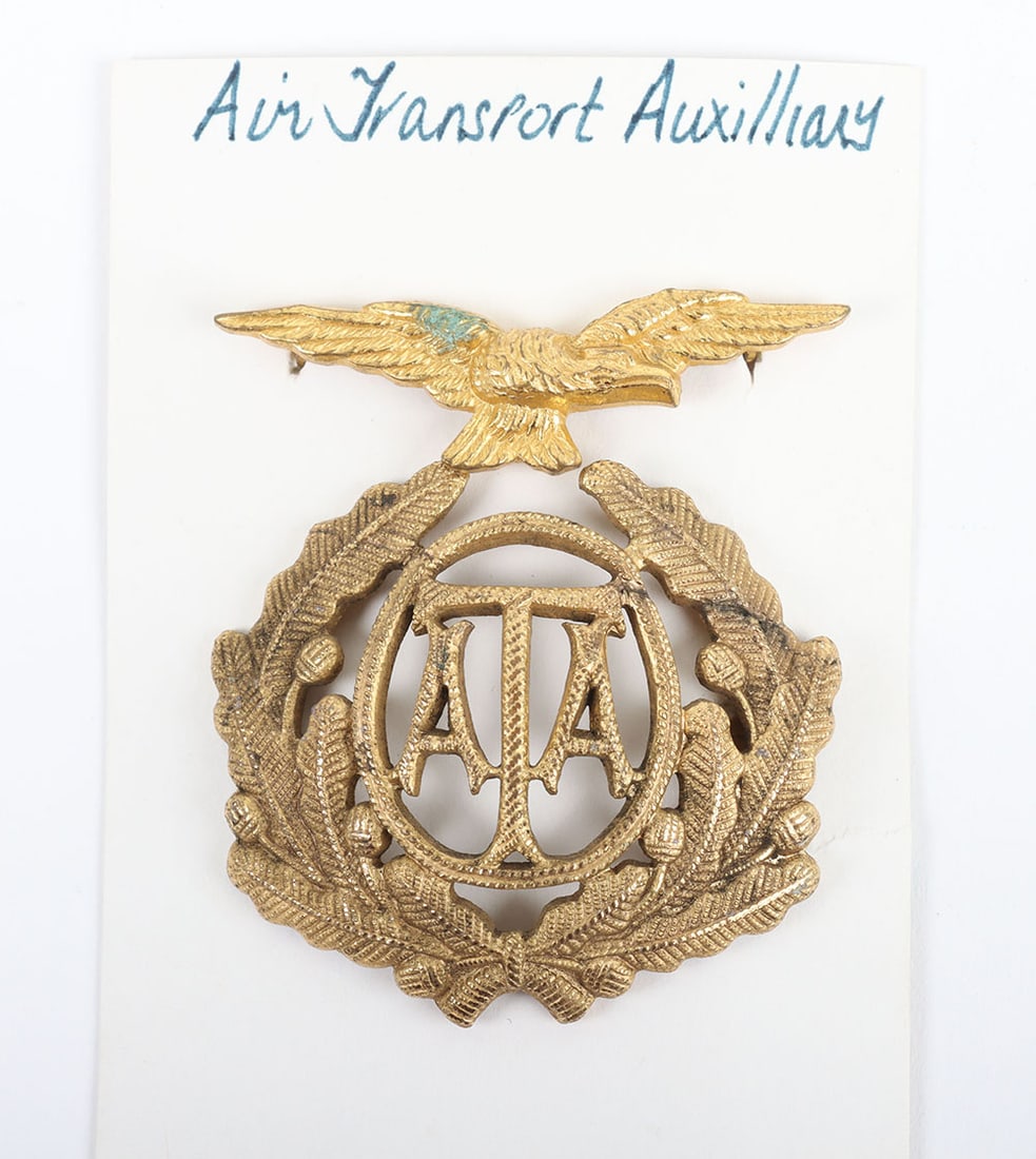 WW2 British Air Transport Auxiliary (A.T.A) Cap Badge: WW2 British Air Transport Auxiliary (A.T.A) Cap Badge, gilt metal ATA within wreath with blade fittings to the reverse. Mounted on card with gilt metal RAF eagle badge with blade fittings to the rever