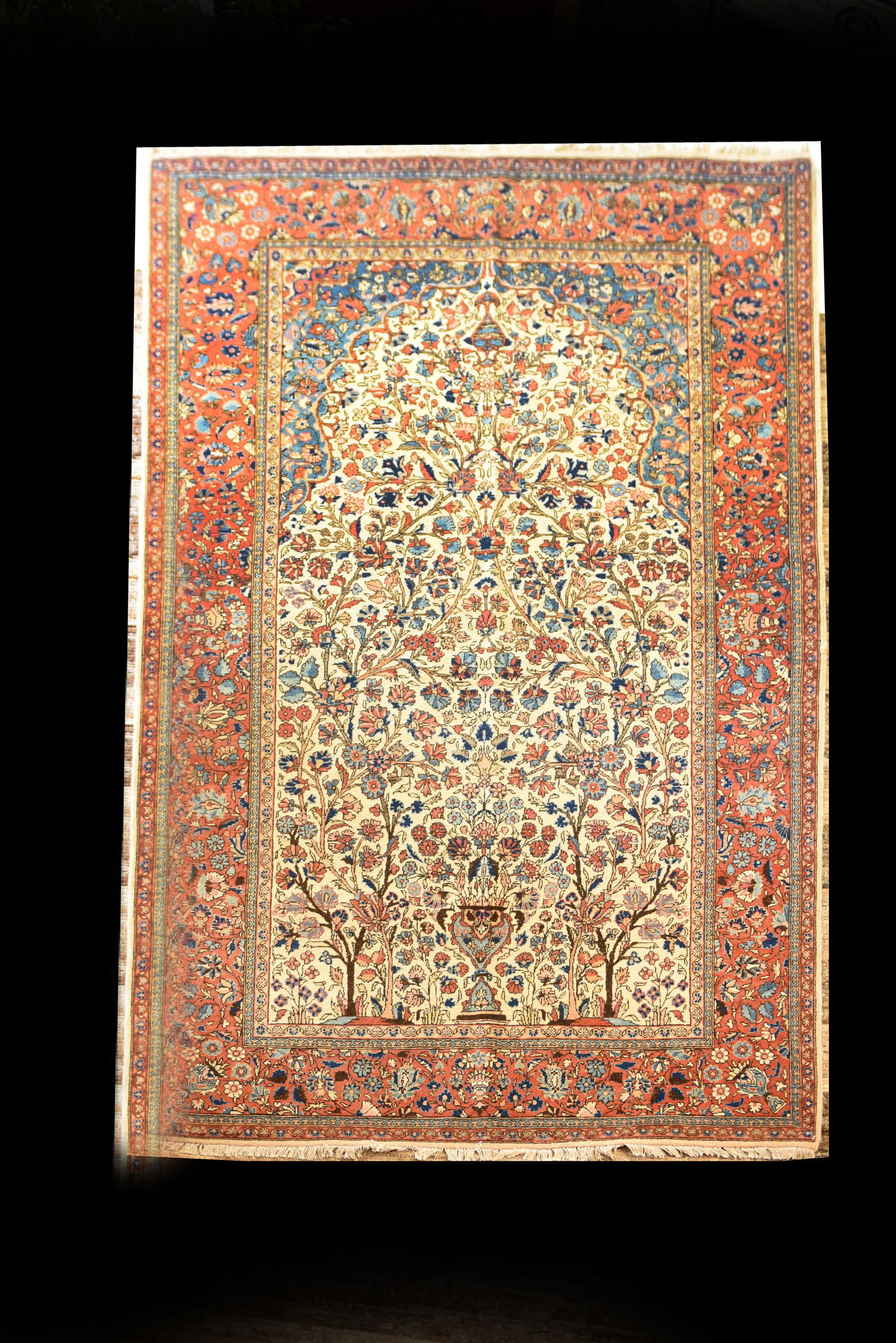 Antique Persian Sarouk Rug,7'2" x 4'4": This is an antique Sarouk Persian rug, measuring 7'2" x 4'4". It features a classic tree-of-life design on an ivory field, with two prominent stylized trees flanking a central vase from which an abund