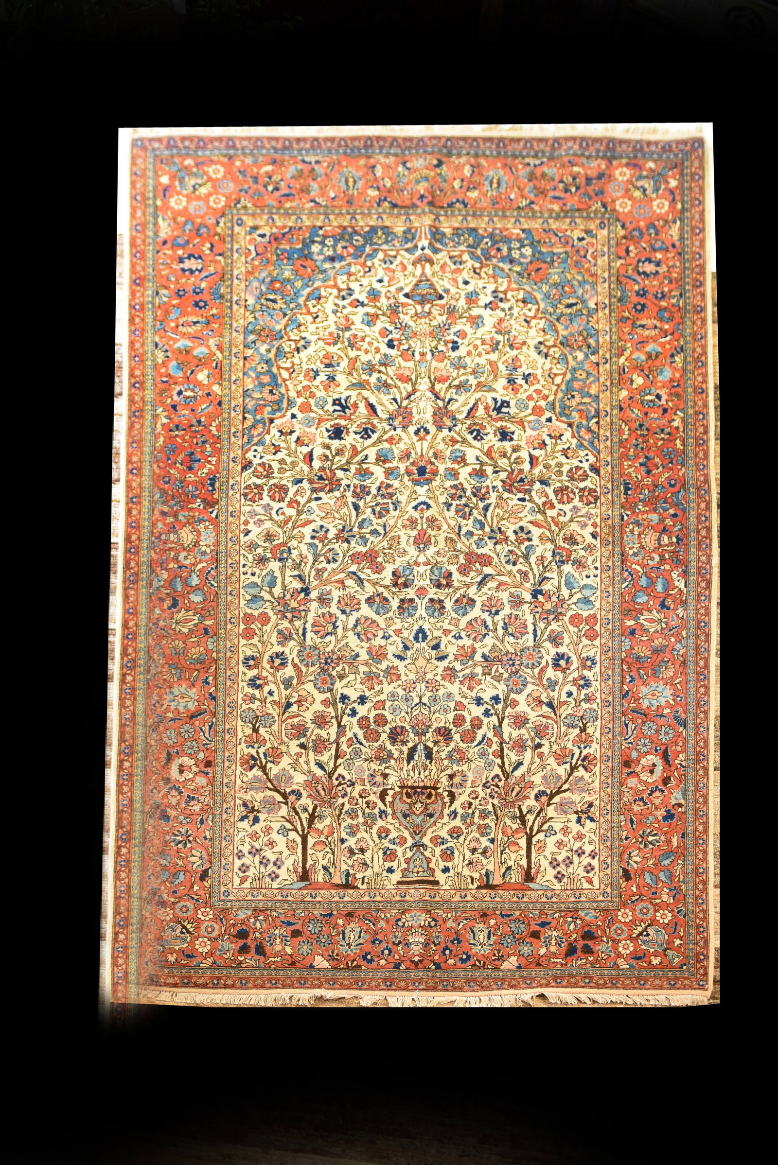 Antique Persian Sarouk Rug,7'2" x 4'4": This is an antique Sarouk Persian rug, measuring 7'2" x 4'4". It features a classic tree-of-life design on an ivory field, with two prominent stylized trees flanking a central vase from which an abund